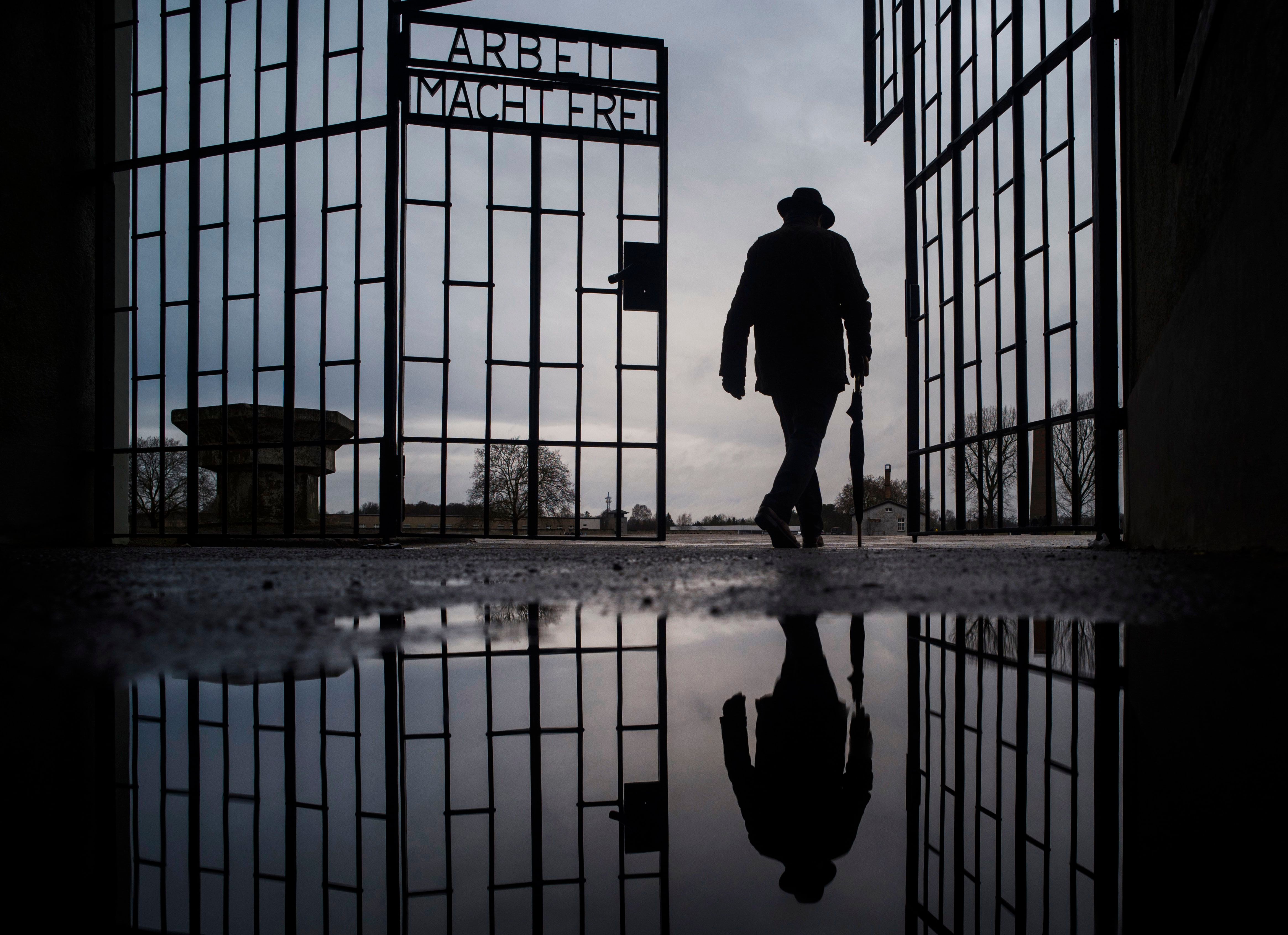Un hombre cruza la puerta del campo de exterminio nazi de Sachsenhausen, en la que dice en alemán "El trabajo los hará libres", durante el Día Internacional de Recuerdo del Holocausto, en la localidad de Oranienburg, a unos 30 kilómetros al norte de Berlín, Alemania (AP Foto/Markus Schreiber, Archivo)