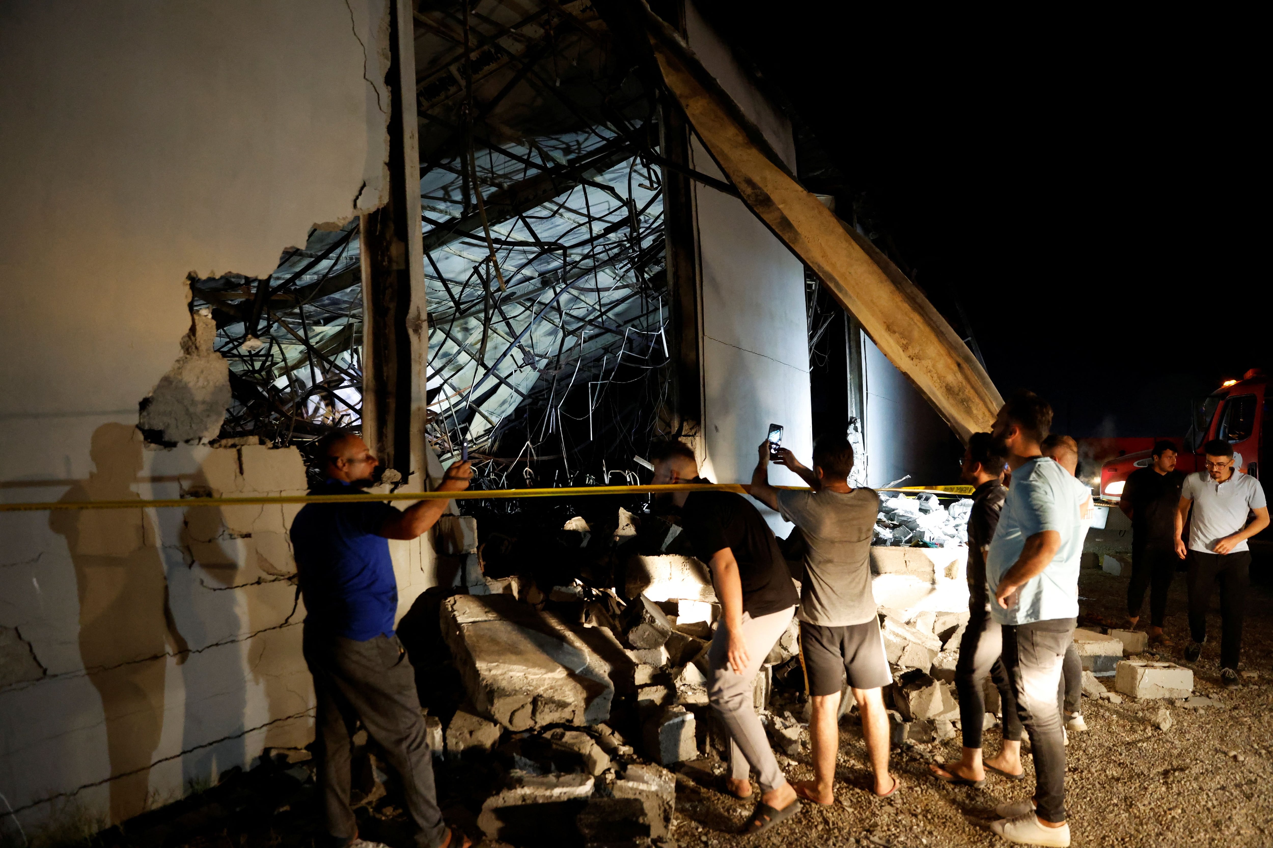 Varias personas se reúnen en el lugar donde se produjo un incendio mortal durante la celebración de una boda, en el distrito de Hamdaniya, en la provincia iraquí de Nínive, Irak, 27 de septiembre de 2023. REUTERS/Khalid Al-Mousily