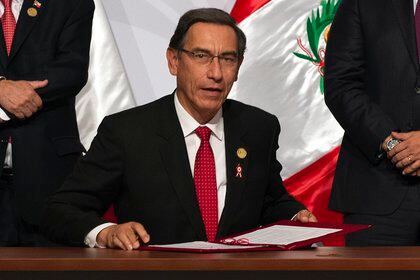 (FILES) In this file picture taken on July 6, 2019 Peru's President Martin Vizcarra signs a copy of the Lima Agreement at the end of the Pacific Alliance Summit, in Lima. - The government of Peruvian president Martin Vizcarra on September 14, 2020 sought a Constitutional Court injunction to block an impeachment vote due later this week. Congress voted late Friday to open impeachment proceedings against Vizcarra for "moral incapacity" over accusations he incited aides to lie to anti-graft investigators. (Photo by Cris BOURONCLE / AFP)