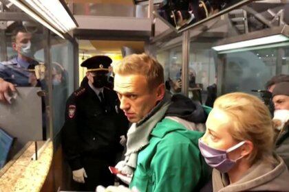 A still image taken from video footage shows law enforcement officers speaking with Russian opposition leader Alexei Navalny before leading him away at Sheremetyevo airport in Moscow, Russia January 17, 2021. REUTERS/Reuters TV