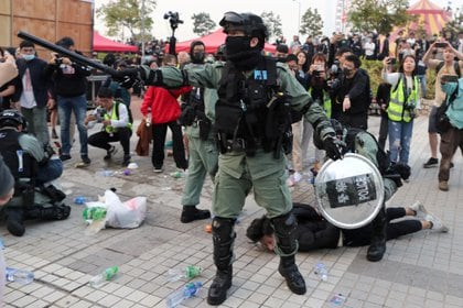 Un policía antidisturbios detiene a un manifestante después de que una bandera china fuera removida del asta de la bandera en una manifestación en apoyo de los derechos humanos de los uigures de Xinjiang en Hong Kong, el 22 de diciembre de 2019 (REUTERS / Lucy Nicholson / Foto de archivo)