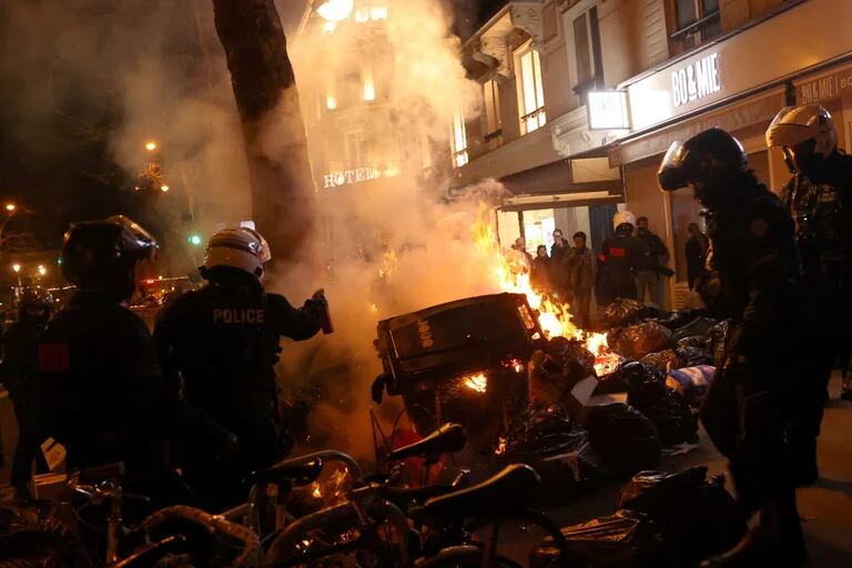 La policía antidisturbios francesa intenta extinguir un incendio en medio de enfrentamientos durante una manifestación c 