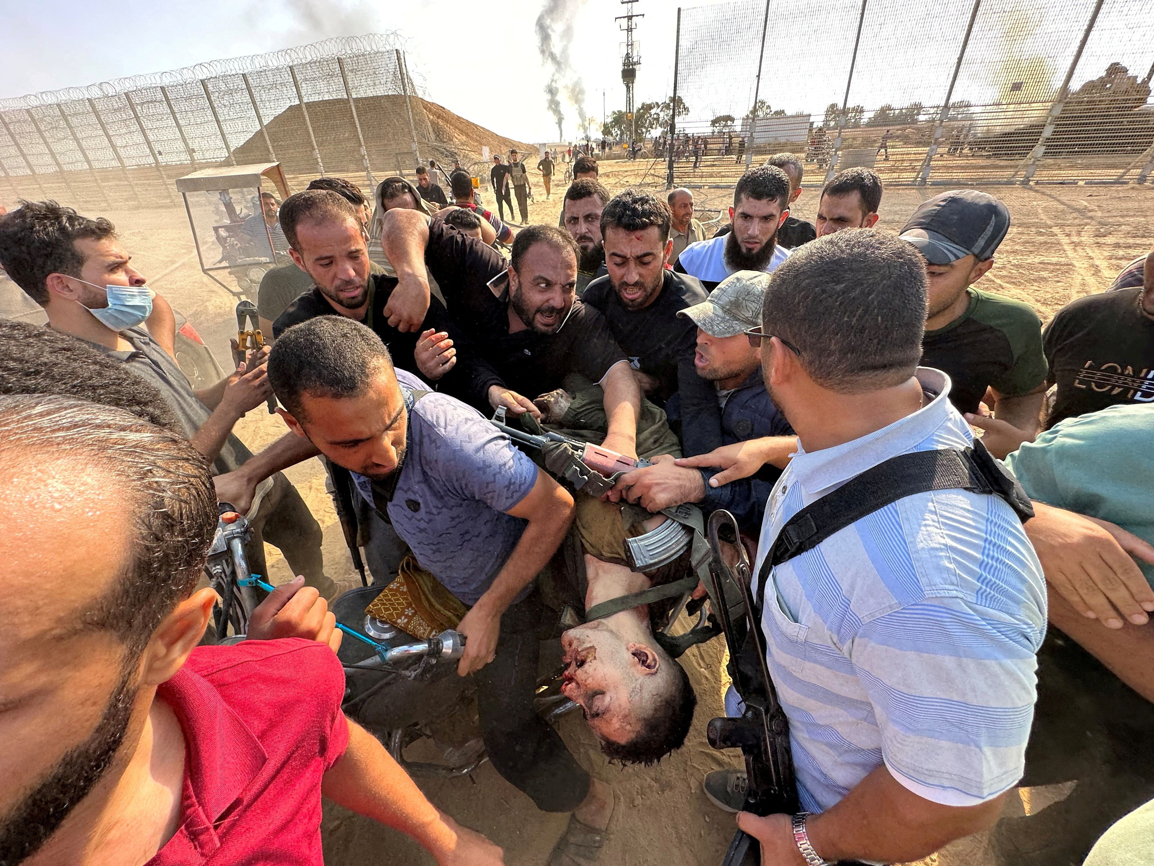 Esta impactante imagen sacudió al mundo el sábado 7 de octubre. terroristas palestinos se llevan a Gaza el cuerpo de un soldado israelí. Cargan el cadáver como si fuera un trofeo. La foto reveló al mundo el horror de la invasión de Hamas al sur del país (Reuters)