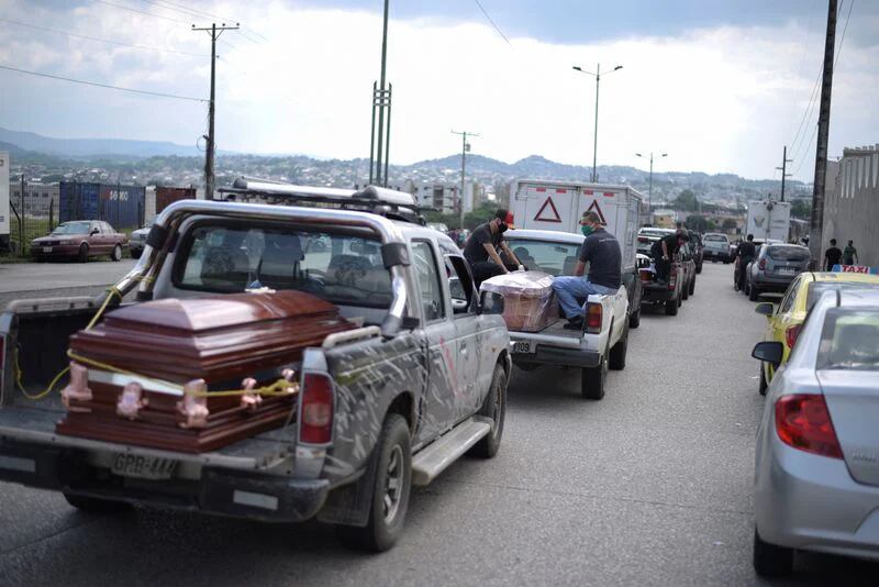 Una fila de vehículos transportando ataúdes haciendo fila fuera de un cementerio en Guayaquil (REUTERS/Vicente Gaibor del Pino)
