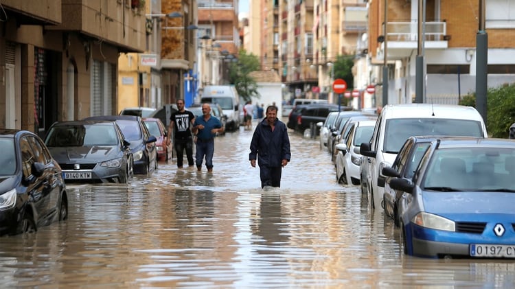La gente camina por una calle inundada mientras las lluvias torrenciales azotan Orihuela, España, el 13 de septiembre de 2019 (REUTERS/Jon Nazca)