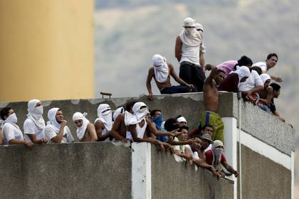 Reclusos se juntan el techo de una prisión en Venezuela durante una revuelta. 