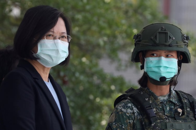 La presidenta de Taiwán, Tsai Ing-Wen, con una máscara facial, observa a los soldados demostrar simulacros en un campamento base militar en Tainan, Taiwán (Reuters)