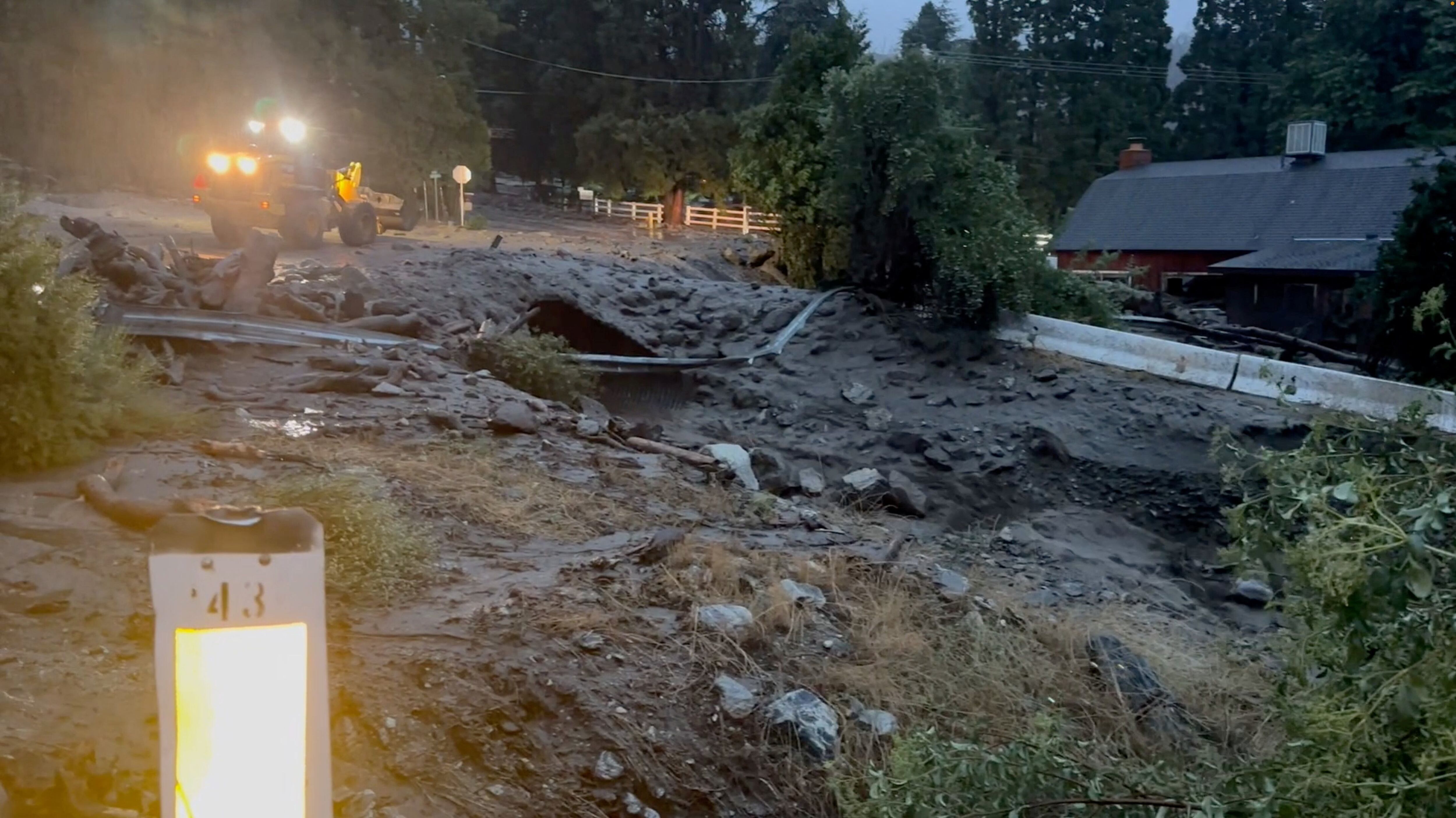 Una vista del agua de inundación que brota y una carretera dañada durante la tormenta tropical Hilary en Oak Glen, California.