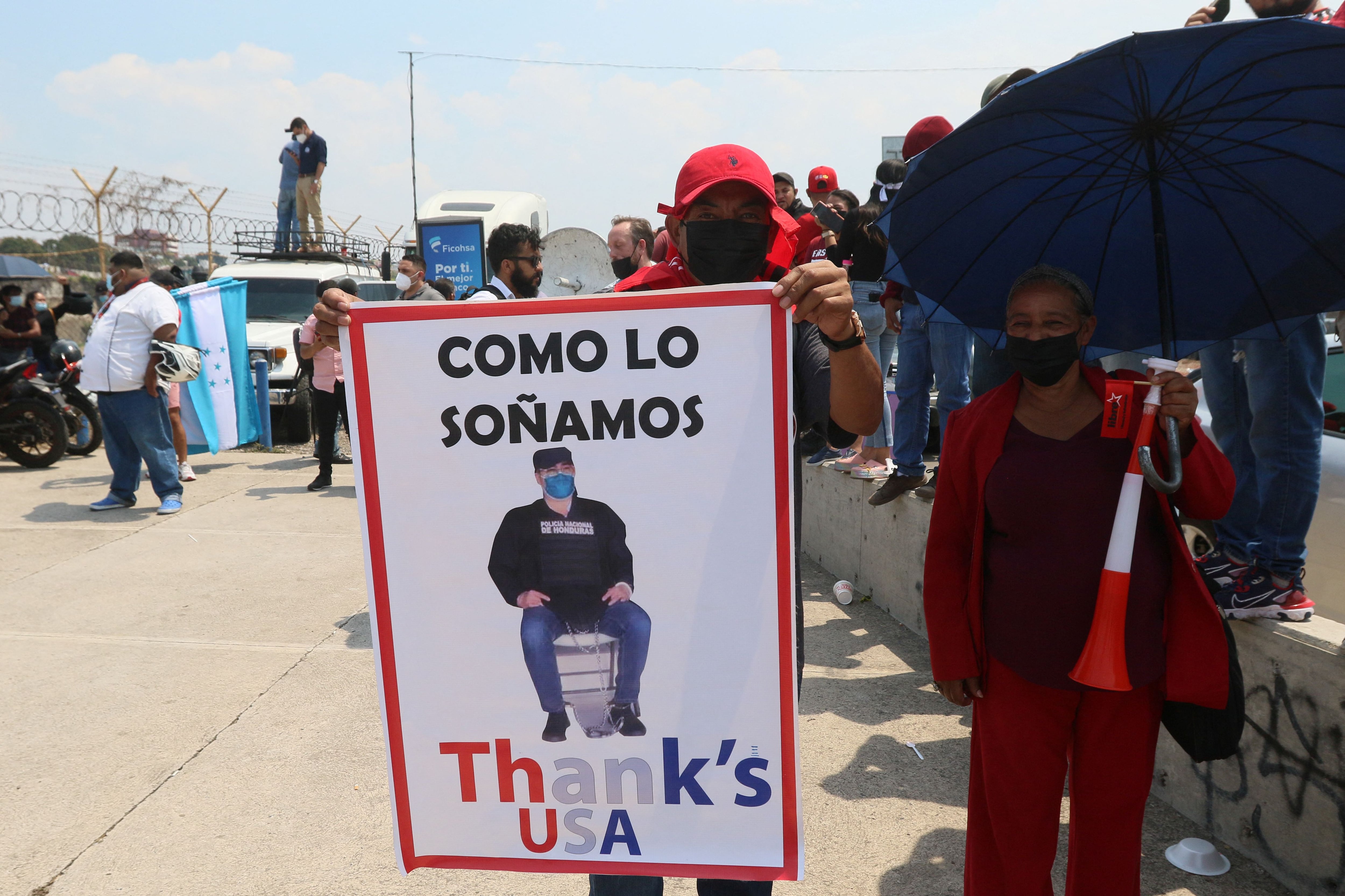 Una mujer espera afuera del aeropuerto con una pancarta (REUTERS/Jonathan Lazo)