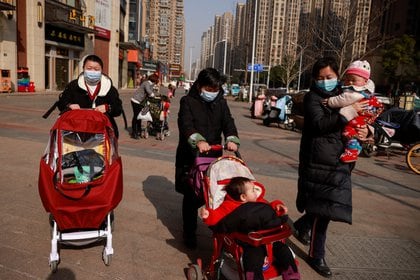 Personas caminan en las calles de Wuhan con tapabocas 