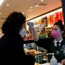 FOTO DE ARCHIVO. Una trabajadora usa un termómetro para verificar la temperatura de un cliente cuando ingresa a una tienda de Starbucks, mientras el país se ve afectado por un brote del nuevo coronavirus, en Pekín, China. 30 de enero de 2020. REUTERS/Carlos García Rawlins.