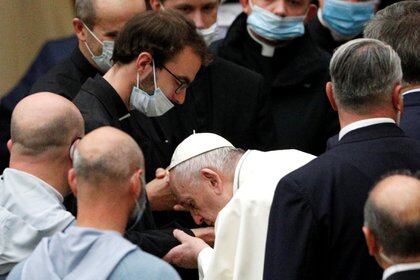 Francisco besa la mano de un sacerdote que trabaja en una cárcel (Reuters)