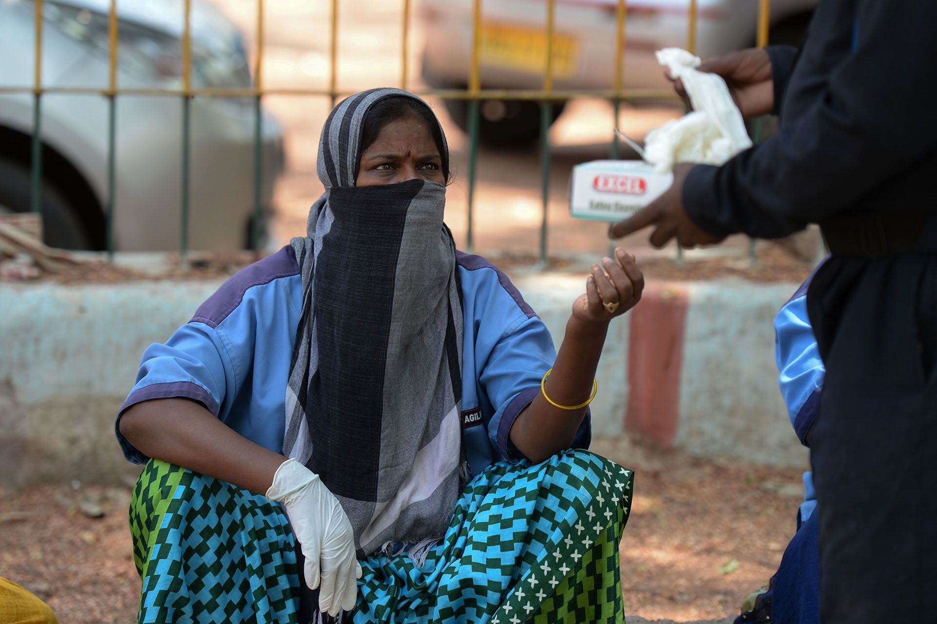 Un barrendero recibe guantes distribuidos por la Dirección de la Unidad Médica y de Salud en Hyderabad el 22 de abril de 2020. (Foto de NOAH SEELAM / AFP)