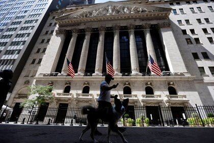 Un hombre pasea un perro frente al edificio de la Bolsa de Valores de Nueva York (NYSE) en Manhattan (Reuters/archivo)