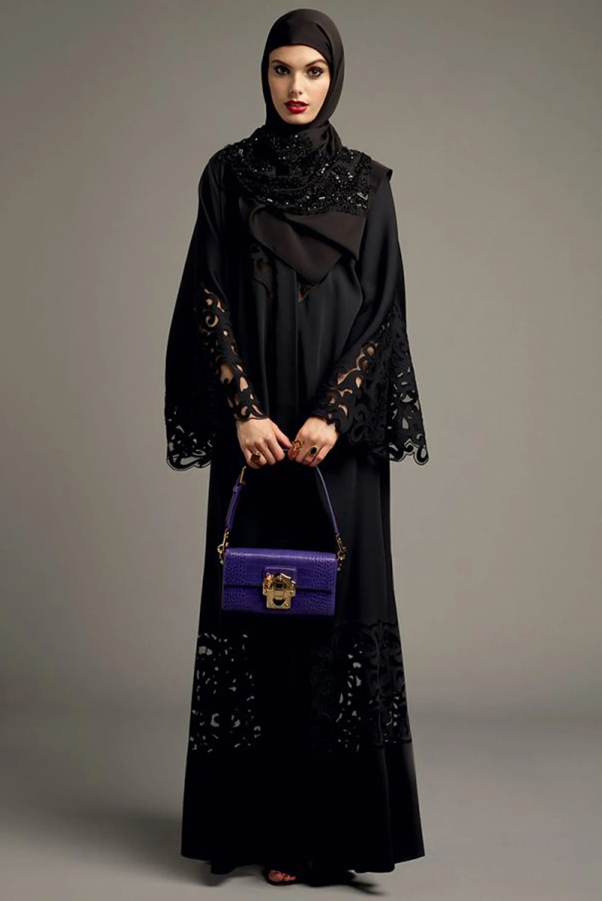 Total black Abaya calada con un diseño único realizado por la firma italiana. Para darle color al look, una mini bag violeta (Vogue Arabia)
