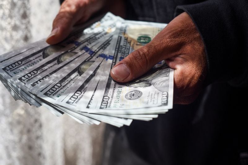 Una persona sostiene varios billetes de cien dólares estadounidenses en El Alto, Bolivia. REUTERS/Claudia Morales