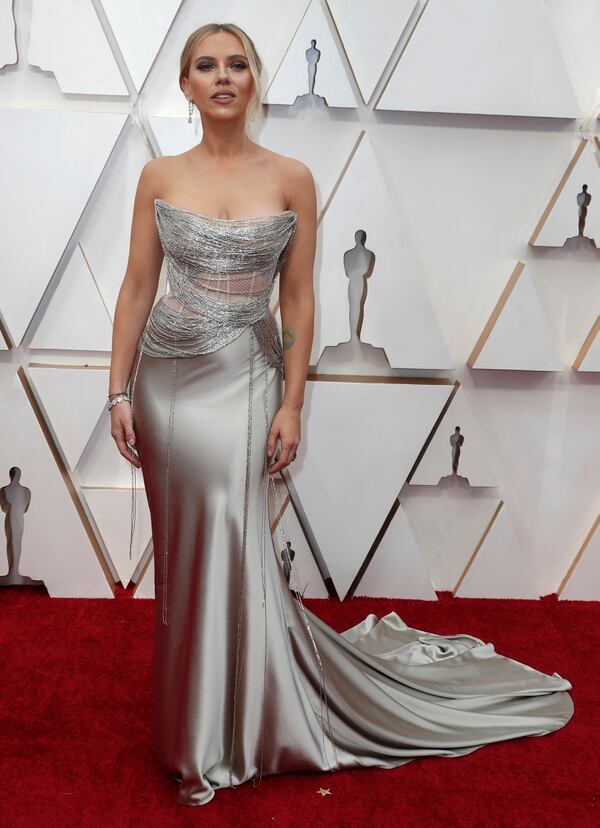 Scarlett Johansson deslumbró con un vestido plateado strapless en punta, con gran cola y detalles de red en el bustier de la pieza. Completó su look un brazalete de brillantes y aros gota 