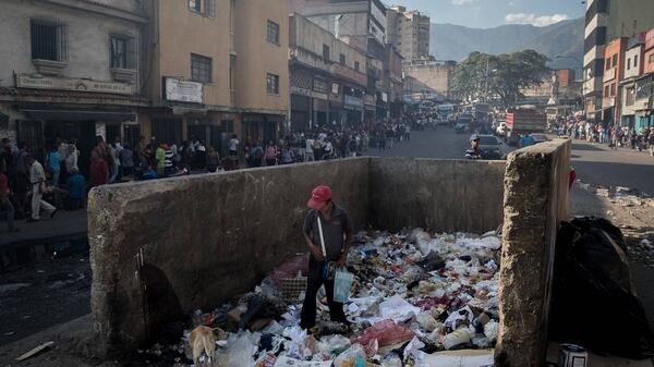 Un hombre busca comida en un basurero de Caracas, Venezuela (Wall Street Journal)