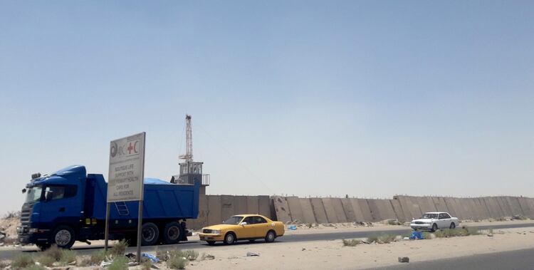 Vehículos en una barrera de seguridad del campo Zubair, luego del impacto del cohete (Reuters)