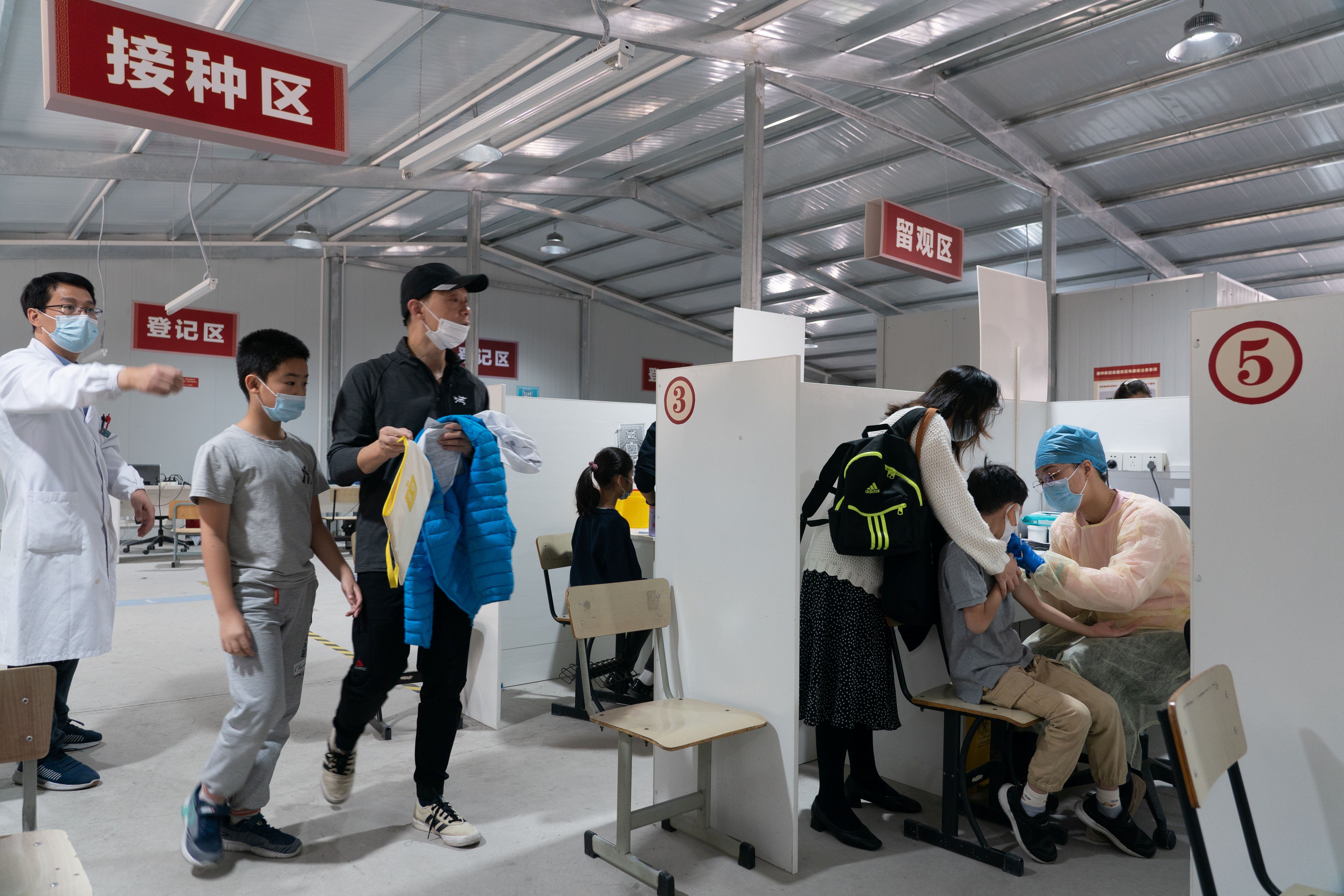 Trabajadores médicos atienden a estudiantes de primaria en un sitio de vacunación mientras la ciudad comienza a administrar la vacuna contra el coronavirus para niños de entre 6 y 11 años, en Shanghai. (China Daily via REUTERS)