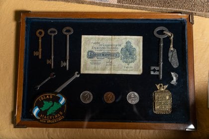 Recuerdos de su misión a Malvinas: llaves, monedas, billetes. Abajo a la derecha, un bocallave de bronce 