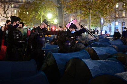 Gendarmerie forces cross Republique square to evacuate migrants and associations, after they installed tents, in Paris on November 23, 2020, one week after migrants were evacuated from a makeshift camp in the northern Paris popular suburb of Saint-Denis without being relocated. (Photo by MARTIN BUREAU / AFP)