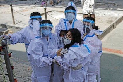 Familiares que usan equipo de protección personal lloran a un hombre, que murió por coronavirus  en un crematorio en Nueva Delhi, India. REUTERS/Adnan Abidi