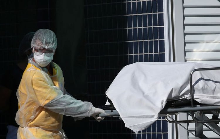 Un trabajador de salud transporta un cuerpo a un camión refrigerado en un hospital de Río de Janeiro (REUTERS/Ricardo Moraes)