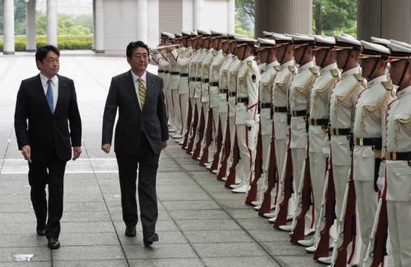 El ministro de Defensa Itsunori Onodera (izquierda) y el primer ministro Shinzo Abe pasa revista a la guardia de honor en Tokio (AFP)