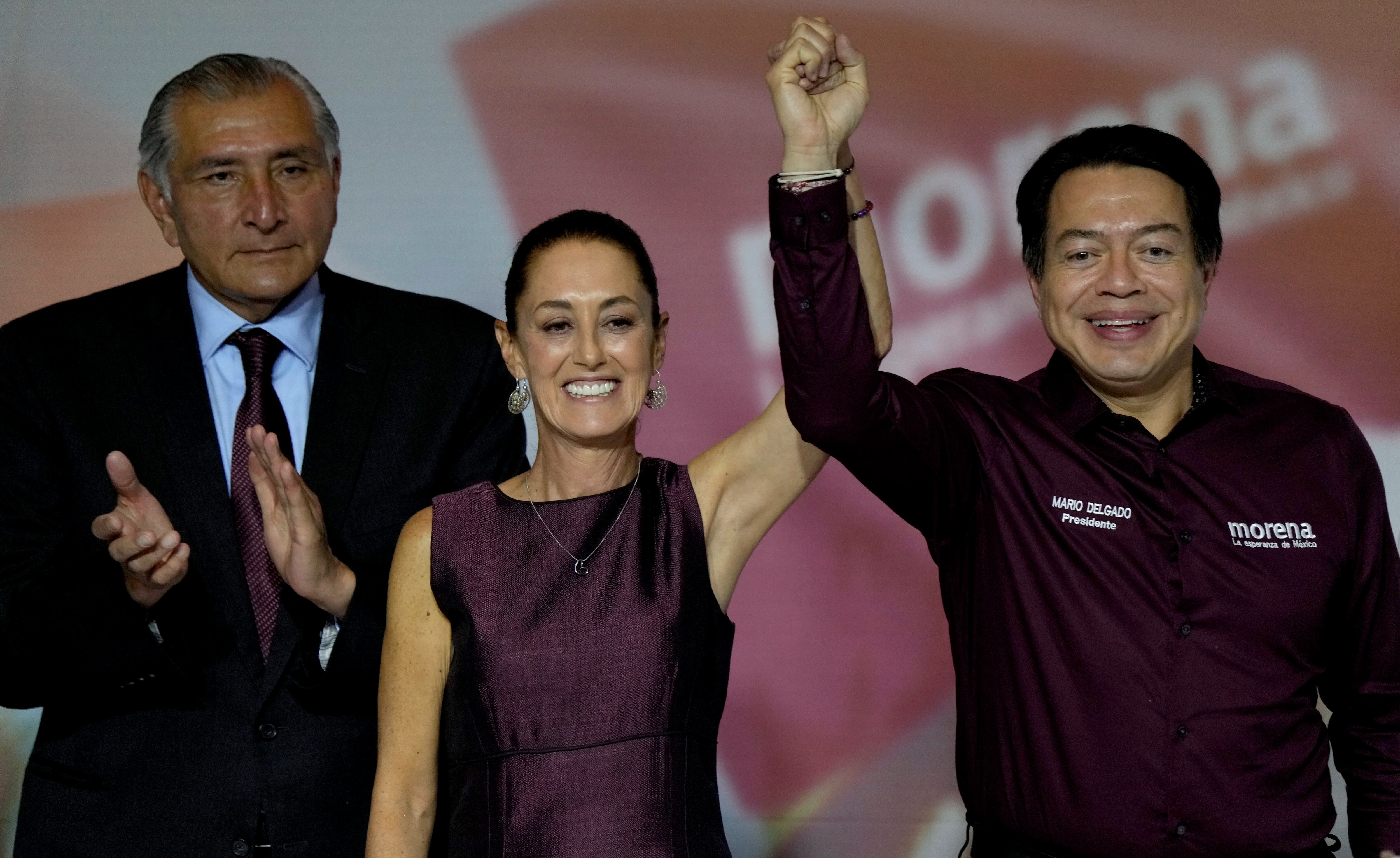 Flanqueada por los líderes del partido, el exministro del Interior, Adán Augusto López (izquierda) y Mario Delgado (derecha), Claudia Sheinbaum celebra su elección como candidata del partido MORENA a las próximas elecciones presidenciales, durante un acto en la Ciudad de México, el 6 de septiembre de 2023. (AP Foto/Fernando Llano)