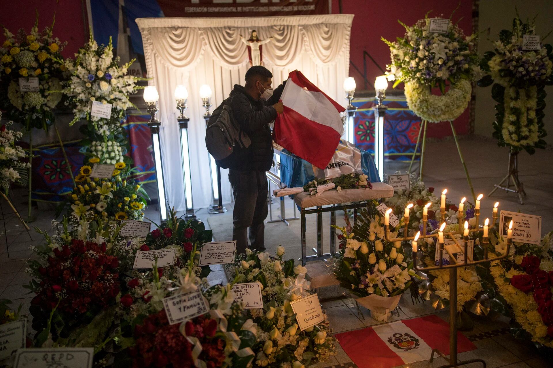 Un joven coloca una bandera sobre el ataúd de Inti Sotelo Camargo en su velorio en Lima (AP Photo/Rodrigo Abd)