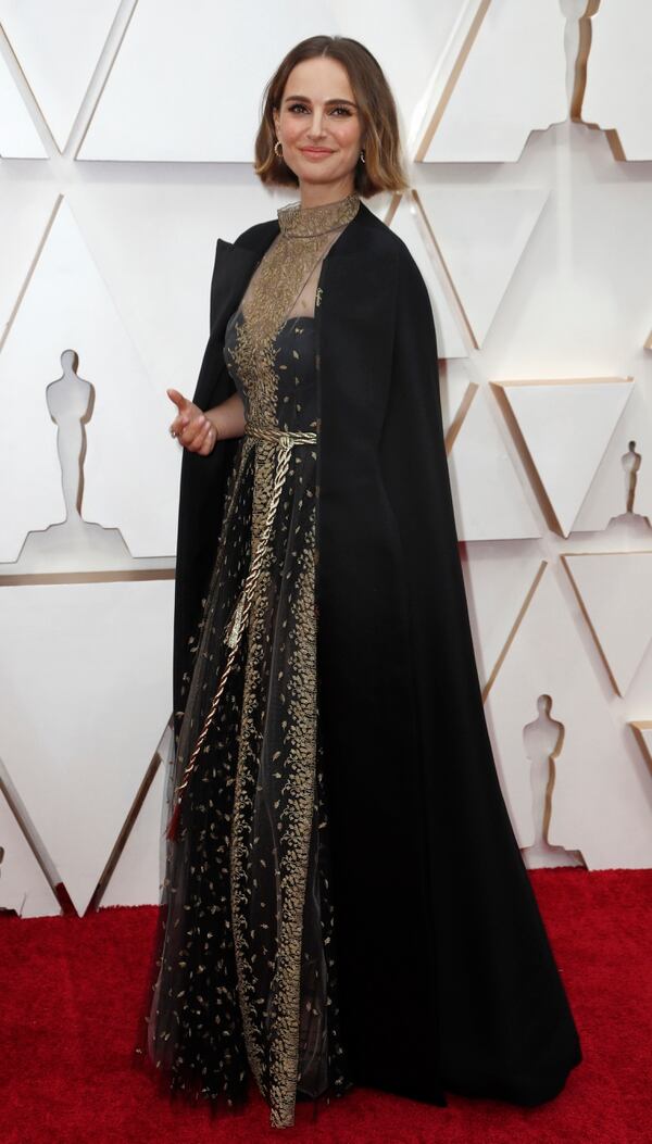 Natalie Portman apostó a un vestido negro bordado de cuello cerrado con una gran capa negra que tenia detalles de grabado con los nombres de las directoras mujeres que no estuvieron nominadas en los premios. Completó su look con pequeñas argollas joya y anillos 