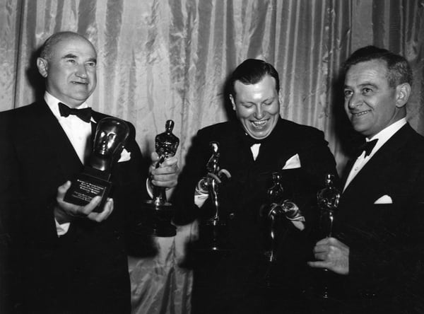 1946: Samuel Goldwyn con el Oscar a mejor película y el premio Irving G. Thalberg Memorial; en el medio, Harold Russell con el de actor secundario y a la derecha, con el de mejor director, William Wyler