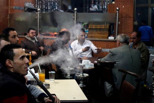 In this Thursday, Jan. 23, 2014 photo, customers smoke water pipes at a coffee shop in Amman, Jordan. In Jordan, a country where smoking is so popular that motorists can be seen puffing away on miniature water pipes in traffic, the kingdom’s government now wants to enforce a Western-style smoking ban in restaurants, cafes and other public places. (AP Photo/Mohammad Hannon)