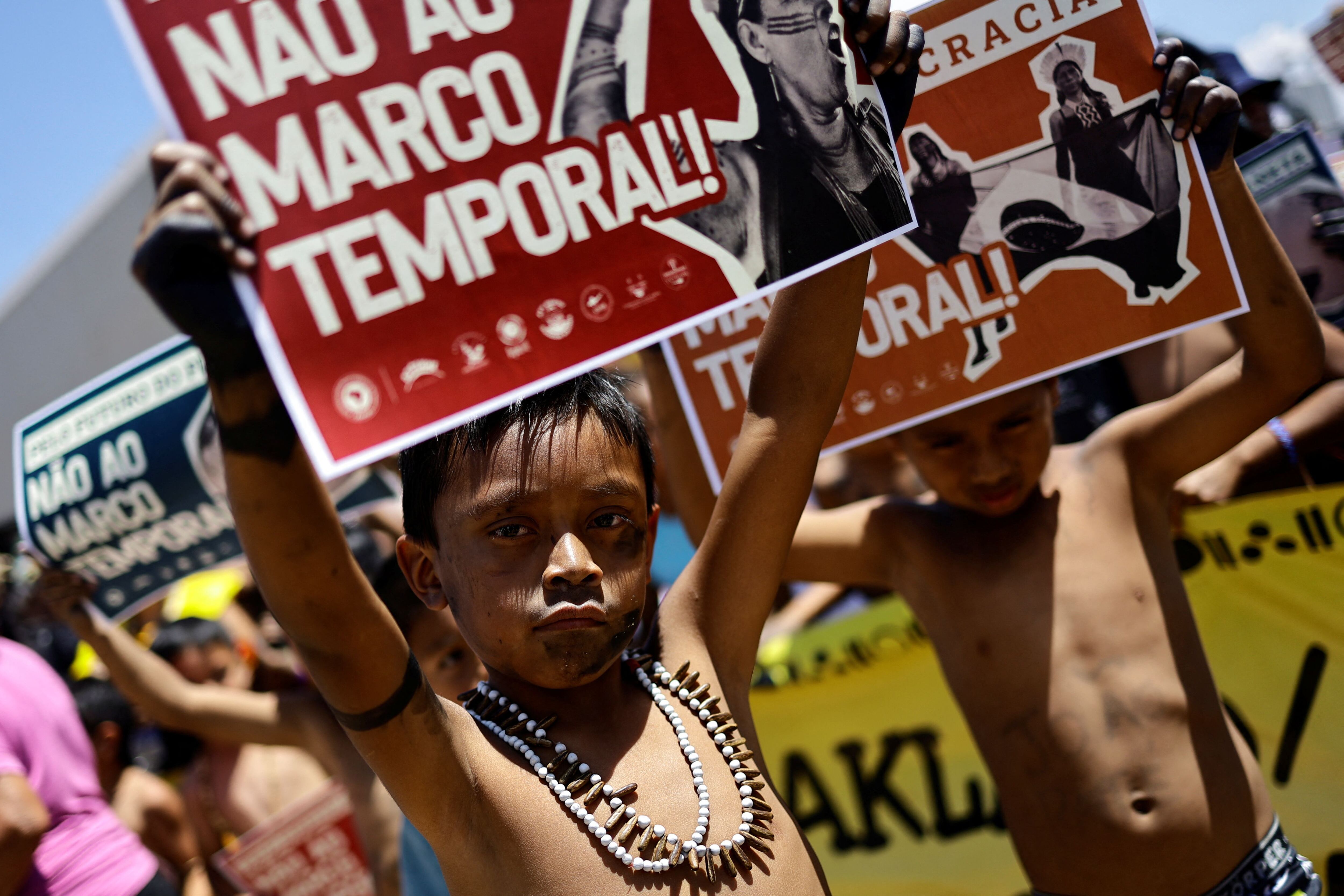 Niños indígenas sostienen carteles para rechazar el “marco temporal” (REUTERS/Ueslei Marcelino)