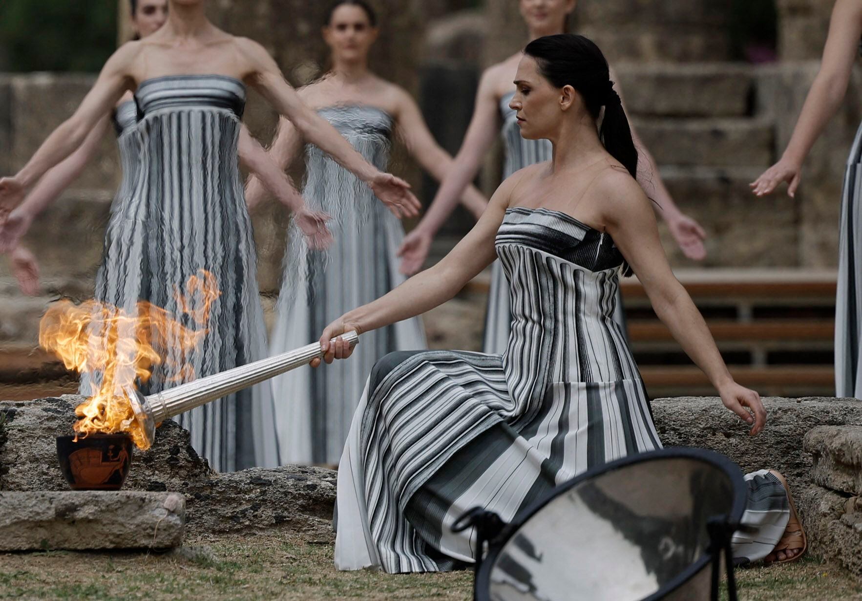 La actriz Mary Mina, en su rol de Suma Sacerdotisa, enciende la antorcha con la llama olímpica