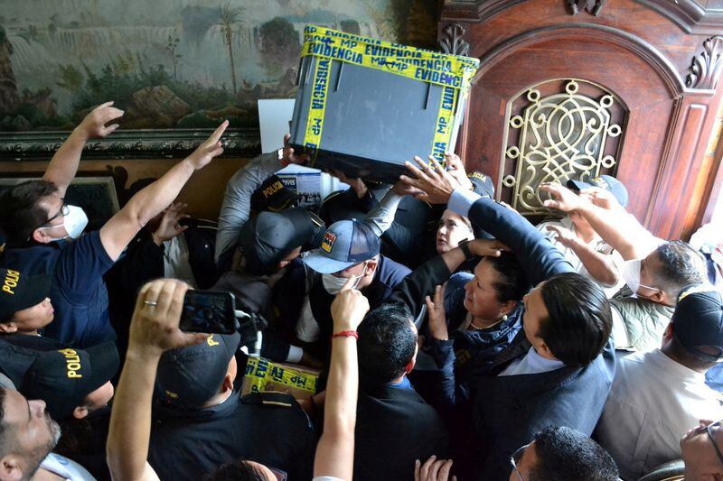Fiscales guatemaltecos del Ministerio Público cargan cajas con actas de las elecciones presidenciales de este año durante un allanamiento en el Tribunal Supremo Electoral, en Ciudad de Guatemala (Guatemalan Supreme Electoral Tribunal/Handout via REUTERS)