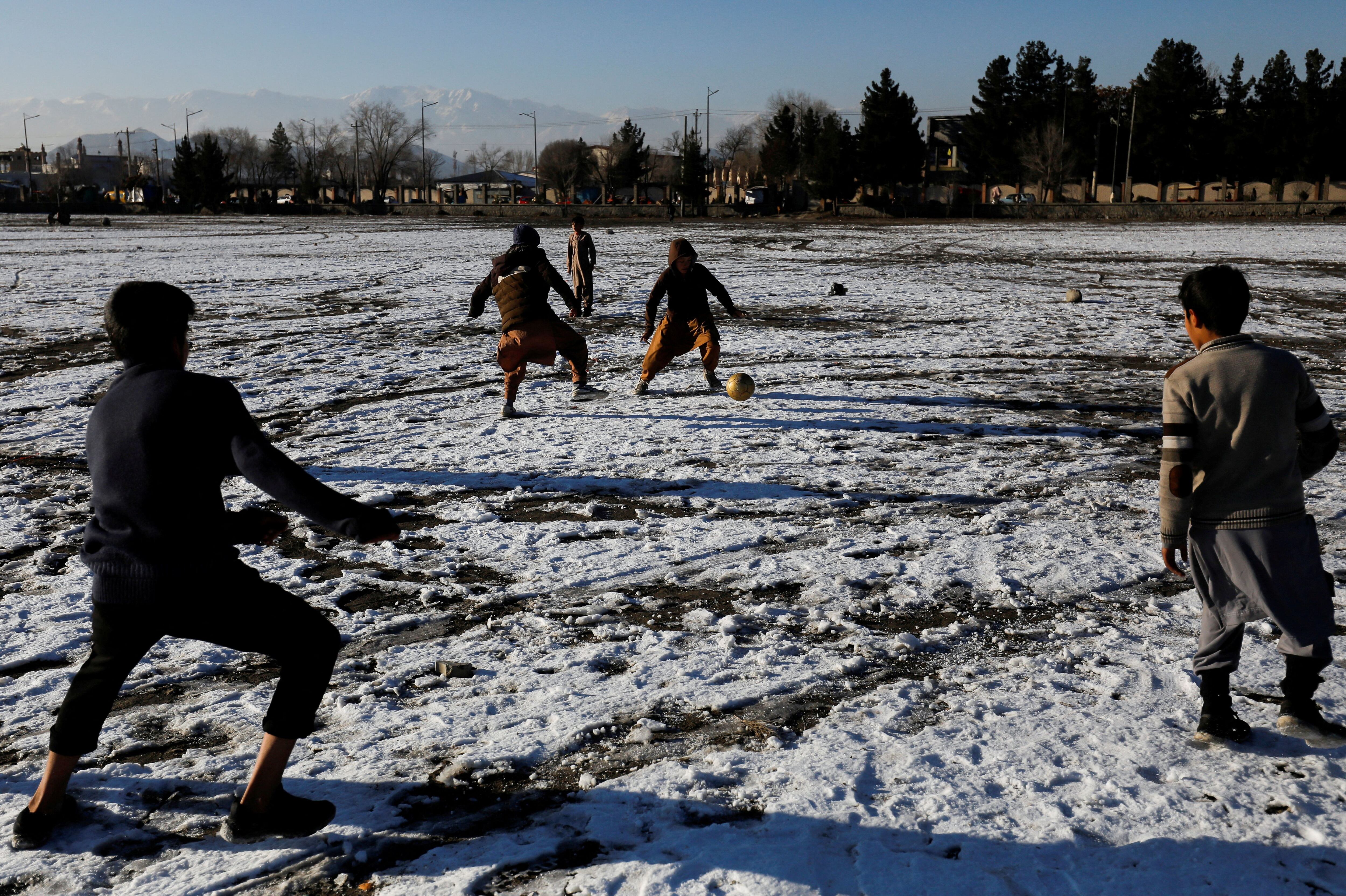 Niños afganos juegan en la nieve (REUTERS/Ali Khara)