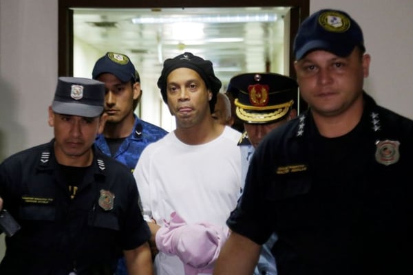 Foto de archivo de Ronaldinho esposado y escoltado por agentes policiales en la Corte Suprema de Paraguay. Mar 7, 2020 REUTERS/Jorge Adorno