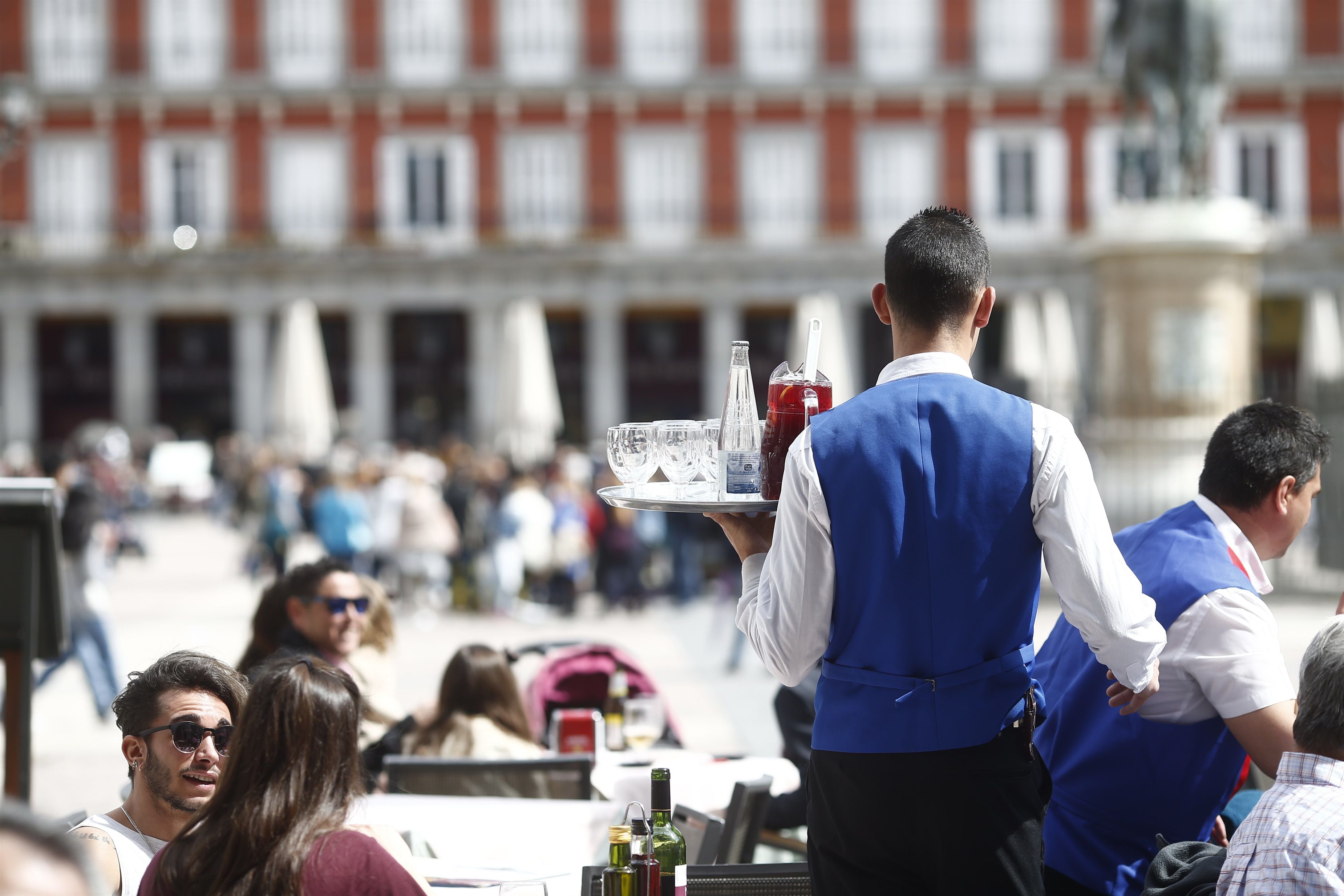 Unos camareros atienden a clientes en un establecimiento hostelero de la Plaza Mayor de Madrid. (Europa Press).
