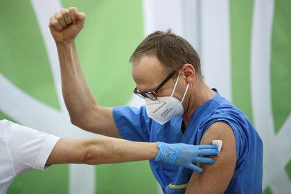 Un trabajador de la salud festeja después de recibir la vacuna Pfizer-BioNTech COVID-19 en el Hospital Favoriten en Viena, Austria (Reuters)