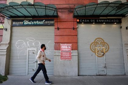 Un hombre camina frente a dos locales cerrados debido a la pandemia, en Ciudad de México. EFE/Sáshenka Gutiérrez/Archivo
