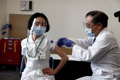 Una médica recibe una dosis de la vacuna contra COVID-19 mientras el país lanza su campaña de inoculación, en Tokio, Japón, el 17 de febrero de 2021. Behrouz Mehri/Pool vía REUTERS