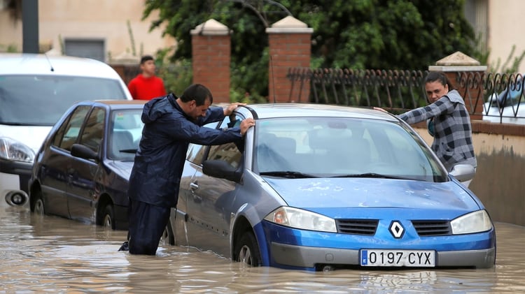 La gente es vista junto a un coche parcialmente sumergido cuando las lluvias torrenciales golpearon Orihuela, España, el 13 de septiembre de 2019 (REUTERS/Jon Nazca)