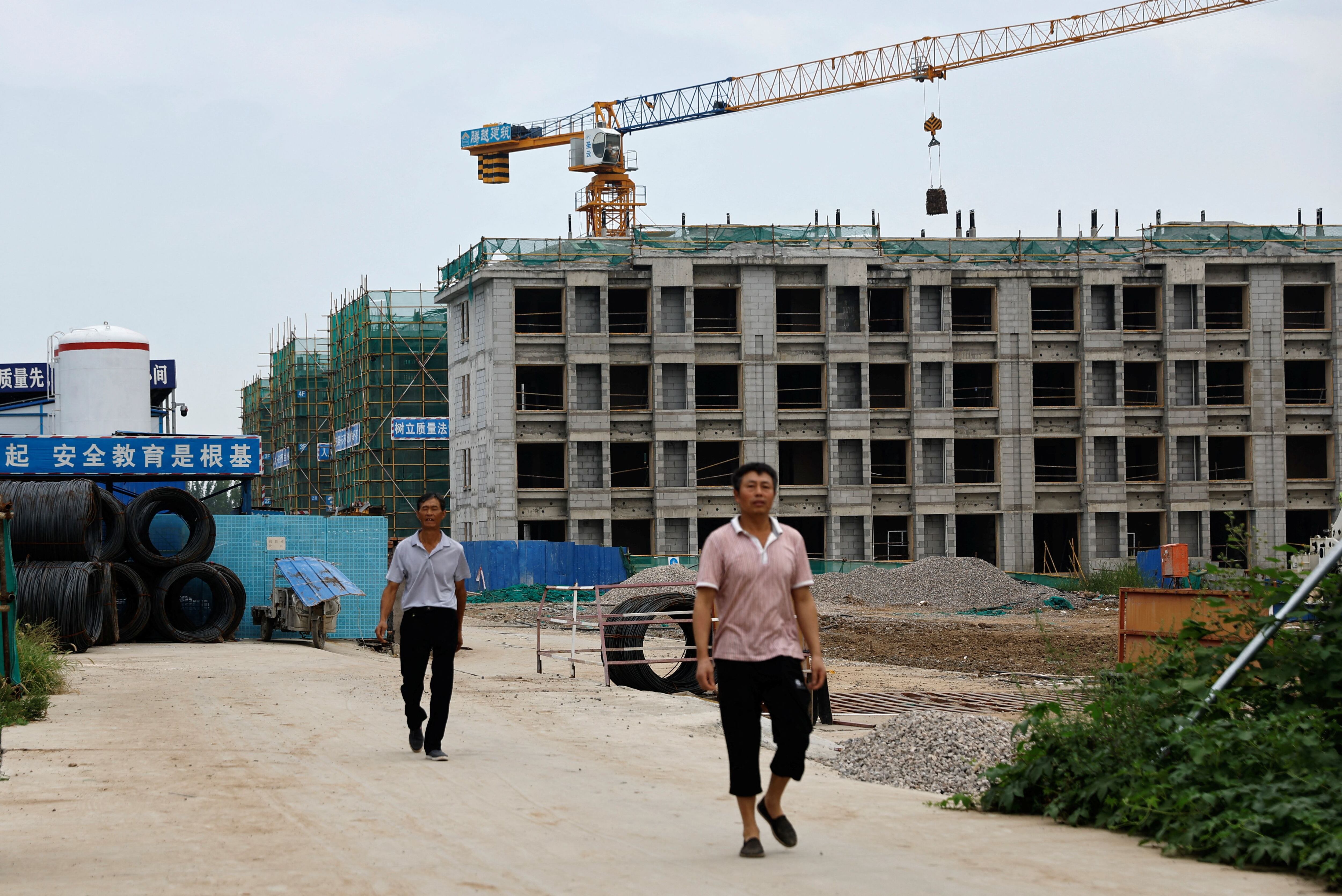 Trabajadores salen de un sitio de construcción de la empresaCountry Garden en Tianjin (Reuters)