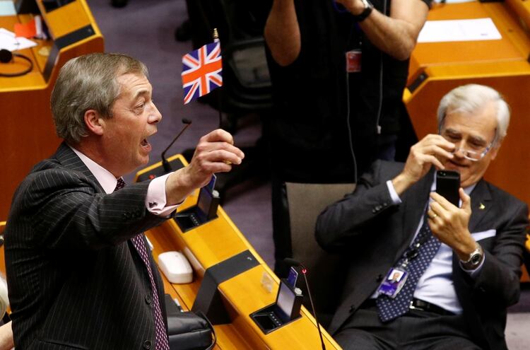 El eurodiputado Nigel Farage, líder del Partido del Brexit, festeja con una bandera del Reino Unido tras la histórica votación en el Parlamento (REUTERS/Francois Lenoir)