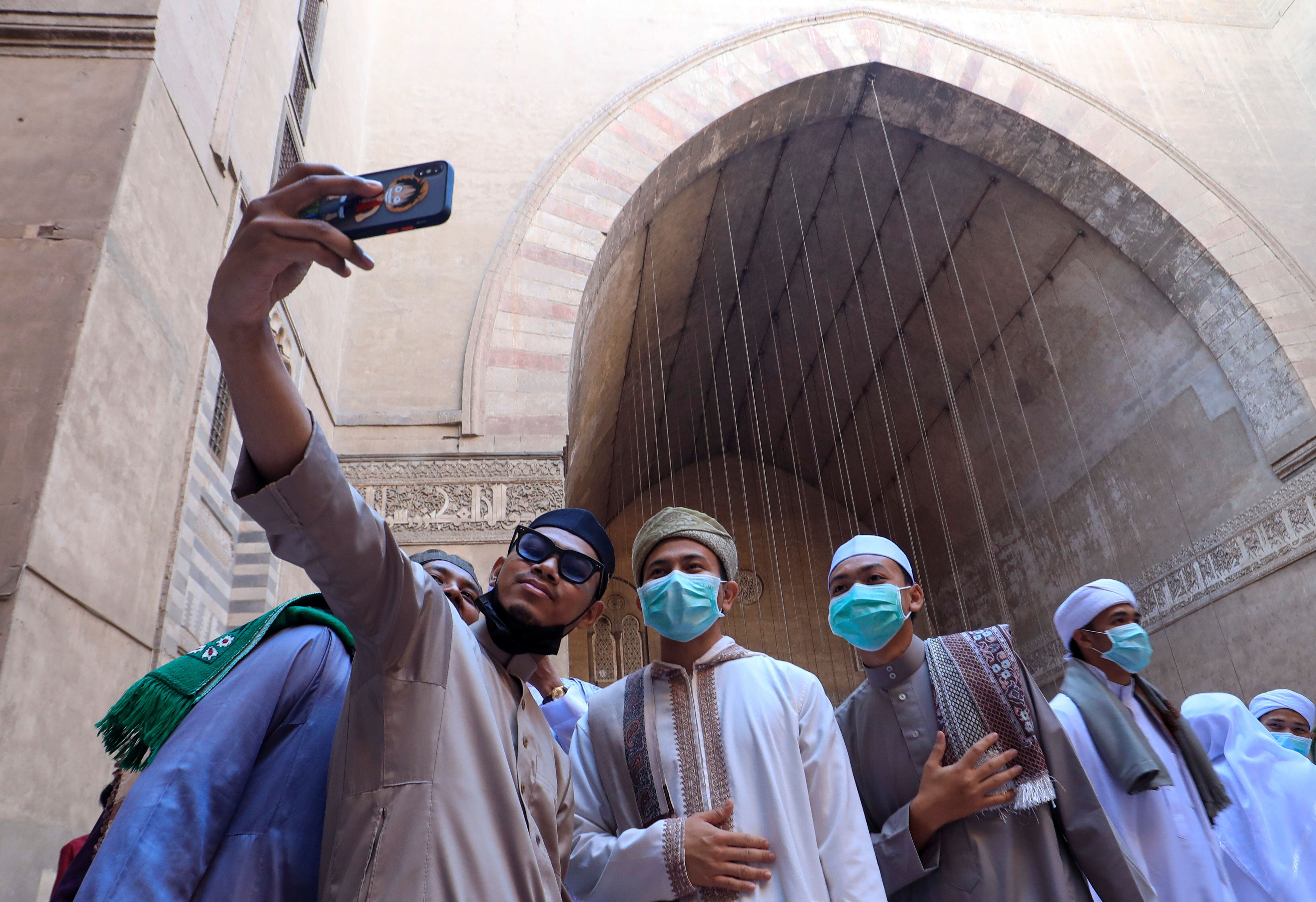 Fieles musulmanes se toman un selfie después de las oraciones de Eid al-Fitr que marcan el final del Ramadán en el interior de la mezquita Al Sultan Hassan en el viejo Cairo, Egipto, el 13 de mayo de 2021 (REUTERS/Amr Abdallah Dalsh)