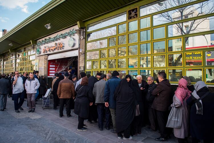 Decenas de personas hacen filas para comprar en un tienda de comida que ofrece descuentos con apoyo estatal. (Ali Mohammadi/Bloomberg)