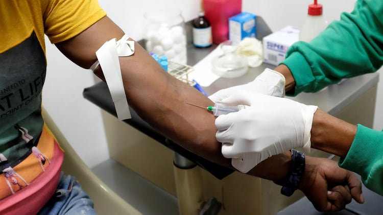 Una enfermera extrae una muestra de sangre para una prueba de VIH en el laboratorio de la ONG 