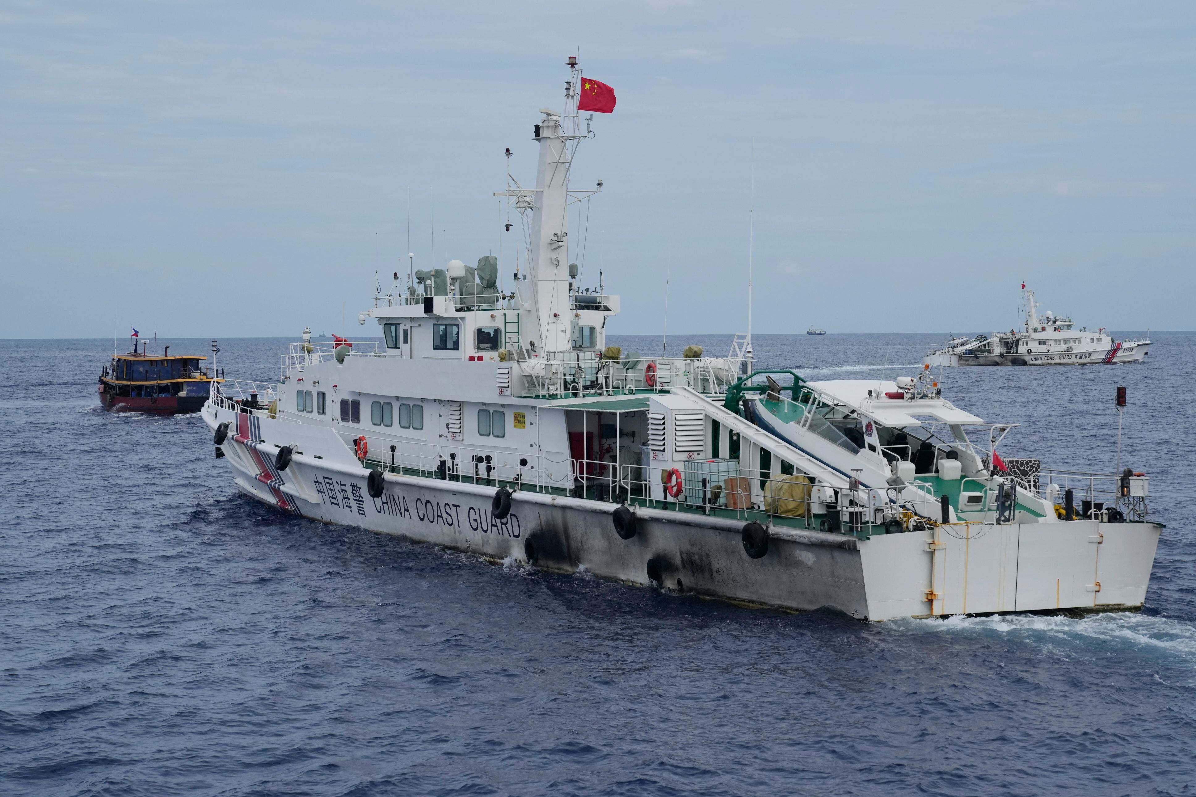 Un barco guardacostas chino intenta bloquear el paso a un barco de suministro de Filipinas, a la izquierda, en su camino hacia el banco de arena Second Thomas Shoal, conocido en la zona como banco de arena Ayungin Shoal, en aguas disputadas del mar de China Meridional, el 22 de agosto de 2023 (AP Foto/Aaron Favila, Archivo)